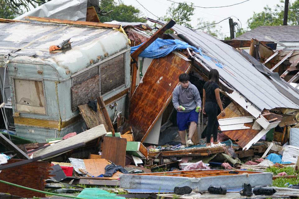 People salvage items from a home after a tornado hit on May 13, 2023, in the unincorporated community of Laguna Heights, Texas, near South Padre Island. (AP Photo/Julio Cortez)
