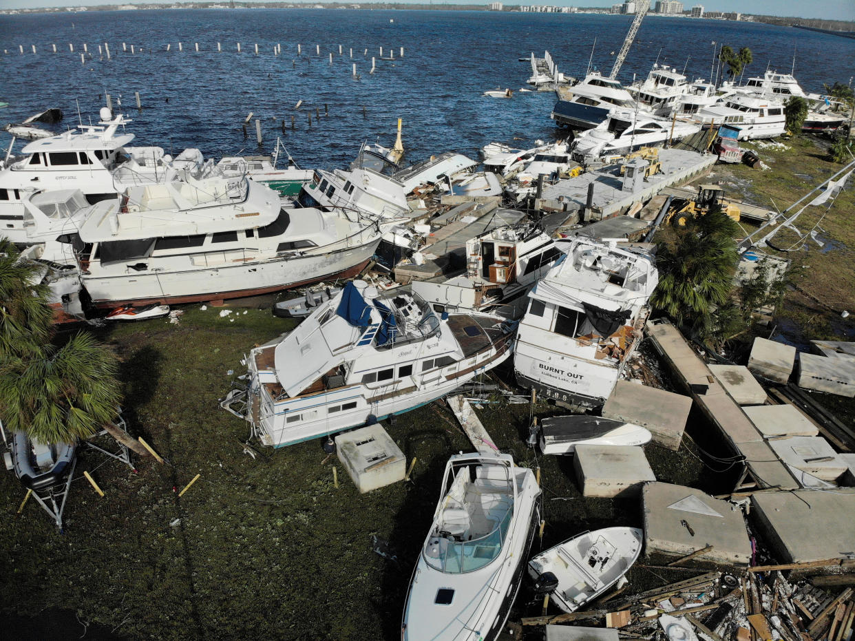 Boats are scattered on land near the coast amid debris in Fort Myers.