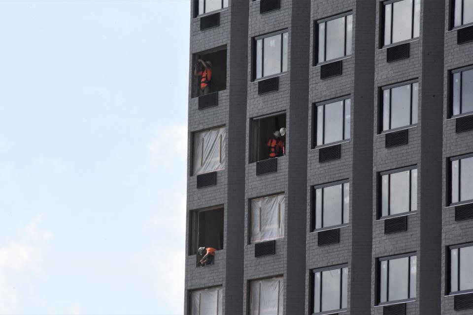 Crews install new windows on the upper floors of the 16-story former McCamly Plaza Hotel on Thursday, June 16, 2022, in Battle Creek.