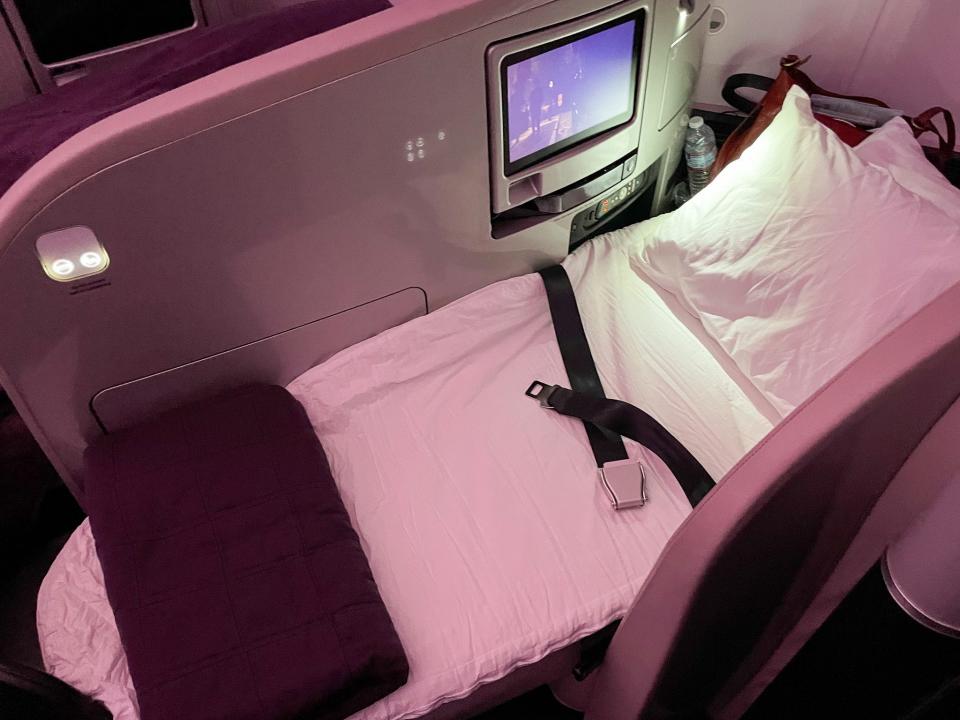 After dinner, flight attendants stopped at each seat to turn it into a bed.