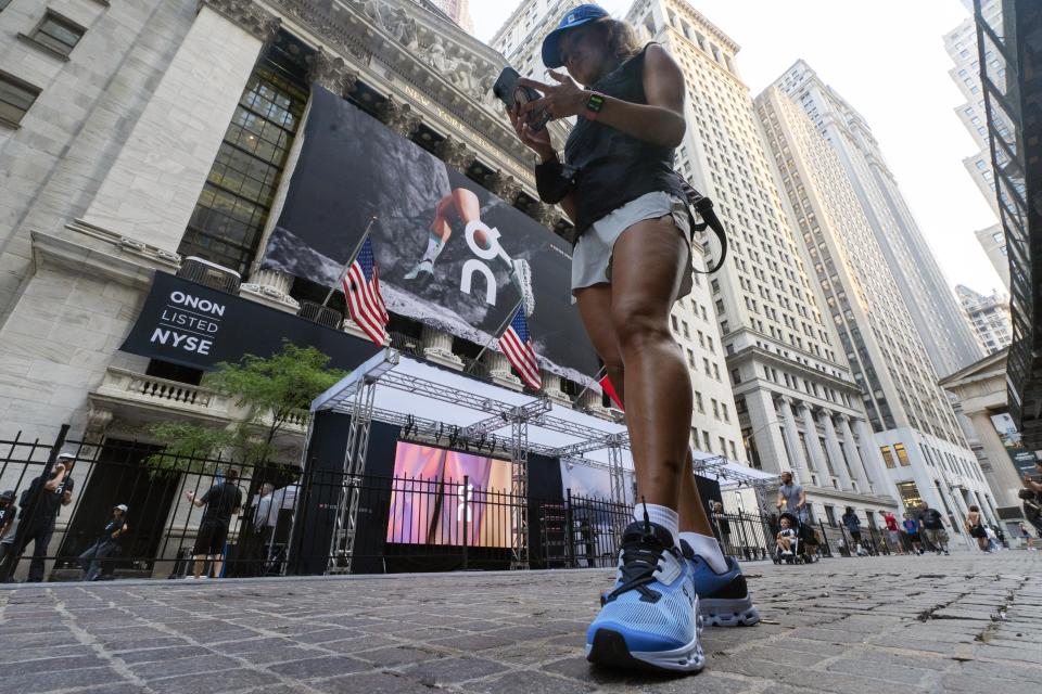 A woman wears On shoes outside the New York Stock Exchange before the company's IPO, Wednesday, Sept. 15, 2021. (AP Photo/Richard Drew)