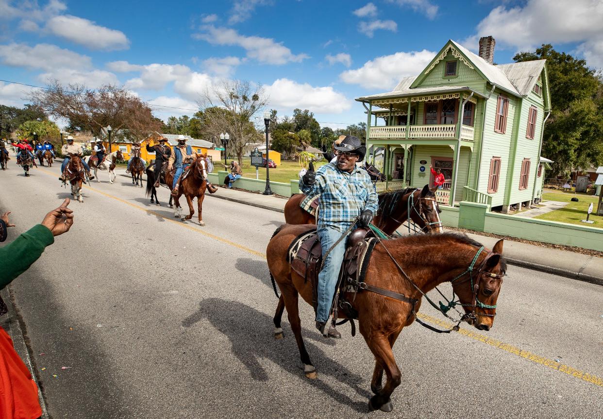 Mounted riders parade by the L.B. Brown house during the Martin Luther King parade in Bartow in 2021.