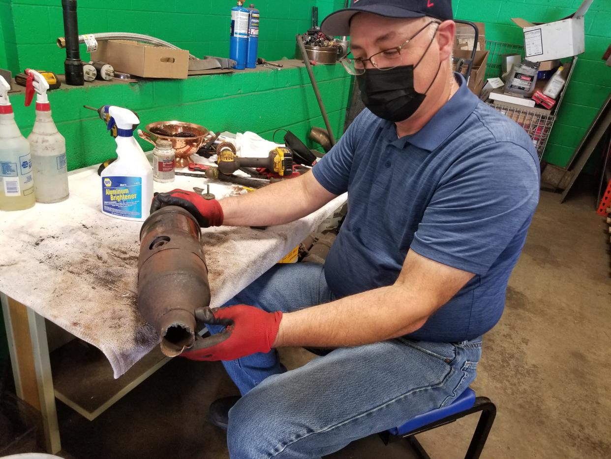 Mike W. Pisani of North Canton Metal Recycling examines a catalytic converter before he purchased it for $300 from a Canton man in this file photo from 2021.