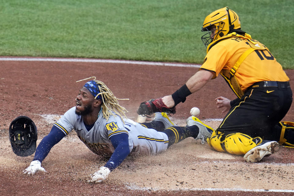 Milwaukee Brewers' Raimel Tapia, left, scores as Pittsburgh Pirates catcher Austin Hedges, right, loses the ball while attempting a tag on a fielder's choice hit into by Brewers' William Contreras off Pittsburgh Pirates starting pitcher Osvaldo Bido during the third inning of a baseball game in Pittsburgh, Friday, June 30, 2023. (AP Photo/Gene J. Puskar)