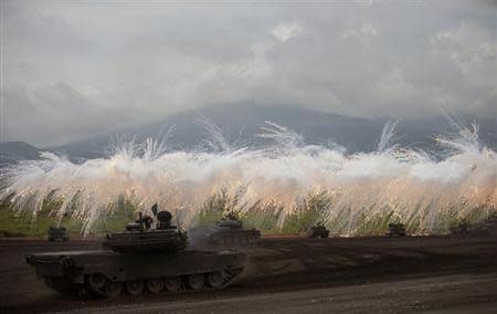 Japanese Ground Self-Defense Force armoured tanks fire during an annual training session near Mount Fuji at Higashifuji training field in Gotemba, west of Tokyo, August 20, 2013. REUTERS/Yuya Shino