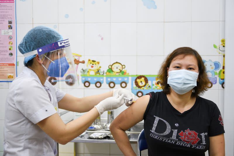 FILE PHOTO: A woman receives a vaccine as Vietnam starts its official rollout of AstraZeneca's COVID-19 vaccine, in Hai Duong