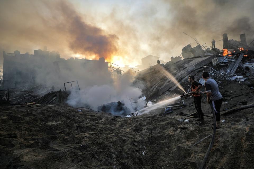 Palestinians try to put out a fire at a destroyed area following Israeli air strikes in Gaza City (EPA)