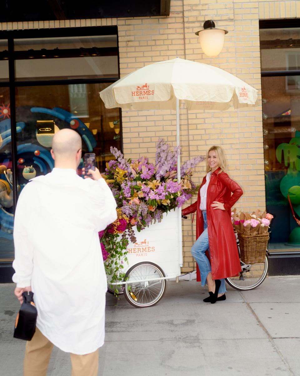A woman poses in front of an Hermès flower cart by Renny & Reed. Many Meatpacking businesses, from Diane von Furstenburg to The Gansevoort Hotel, participated in L.E.A.F.