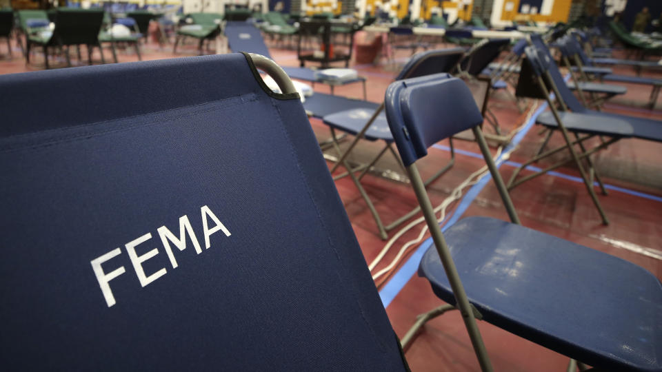 FILE - In this March 24, 2020, file photo, a portable cot with the Federal Emergency Management Agency logo FEMA printed on the backrest, along with other cots, line the basketball court at a makeshift medical facility in a gymnasium at Southern New Hampshire University in Manchester, N.H. On Friday, Oct. 22, The Associated Press reported on stories circulating online incorrectly claiming FEMA workers aren’t subject to a vaccine mandate, and also falsely asserting that they’re being used to replace health care personnel who refuse to comply with such mandates. (AP Photo/Charles Krupa, File)