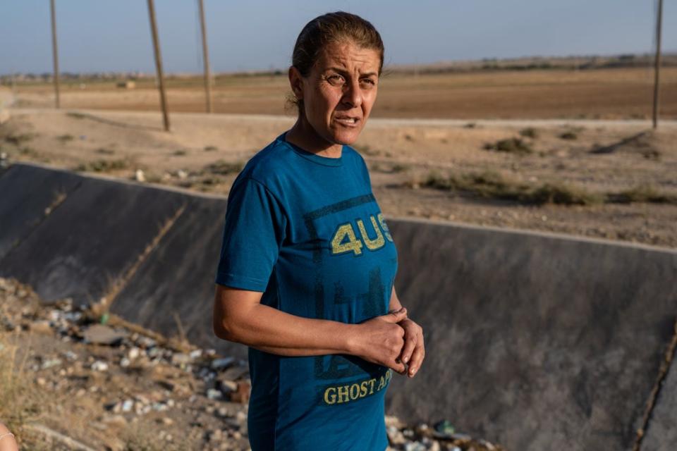 An Assyrian woman stands by dry irrigation canals and barren fields in Um Gharqan (Bel Trew)