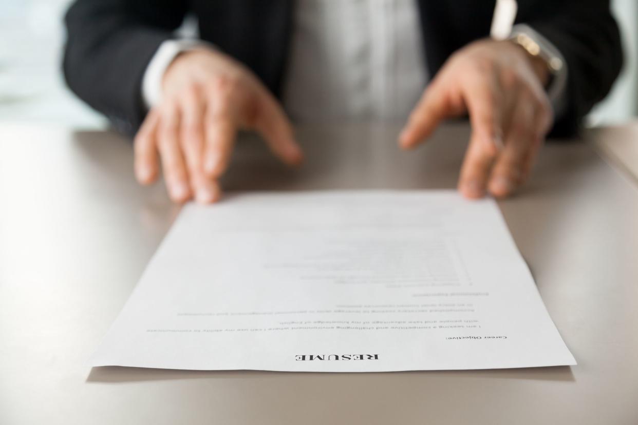 close-up of employer looking at resume on desk