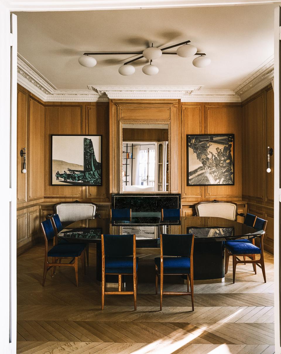 Gio Ponti chairs surround a Stanislas-designed dining table. Angelo Lelli ceiling light; paintings by Gianni Bertini.