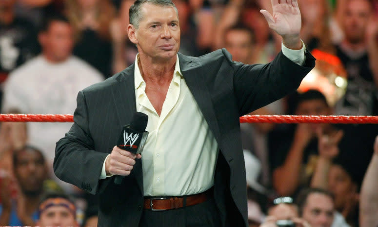Vince McMahon speaking to fans while standing in a WWE ring.