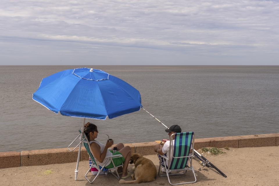 FILE - People fish by the seaside in downtown Montevideo, Uruguay, Jan. 13, 2024. For the eighth straight month, Earth was record hot, according to the European climate agency’s analysis of January 2024. (AP Photo/Matilde Campodonico, File)