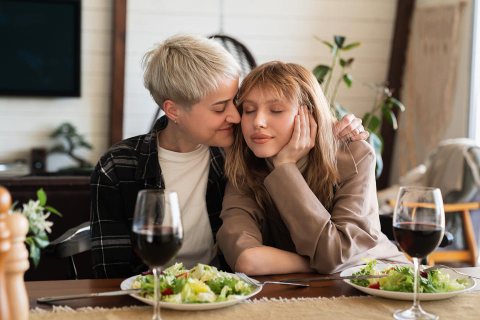 Lesbian love and care concept. LGBT transgender female couple hugging embracing on romantic date with eyes closed showing their passion and trustful relationship