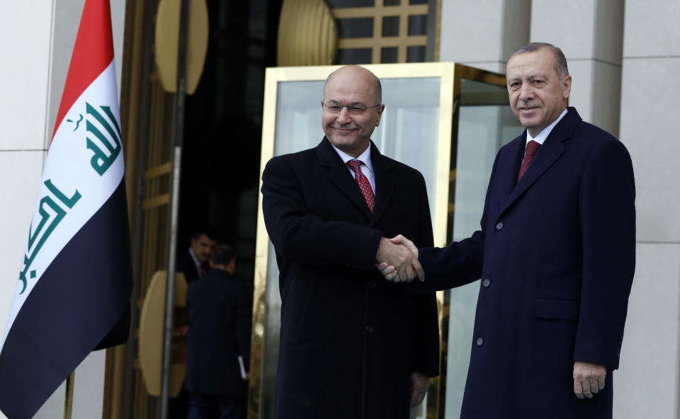 Turkey's President Recep Tayyip Erdogan, right, and Iraq's President Barham Salih shake hands during a welcome ceremony in Ankara, Turkey, Thursday, Jan. 3, 2019. The two were expected to discus bilateral and regional issues, including Syria. (AP Photo/Burhan Ozbilici)