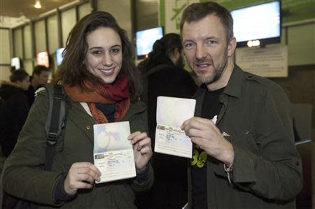 Greenpeace International activists Alexandra Harris and Phil Ball from Britain leave for the departure lounge at St. Petersburg airport bound for London, December 27, 2013, in this handout image courtesy of Greenpeace. REUTERS/Dmitri Sharomov/Greenpeace/Handout via Reuters