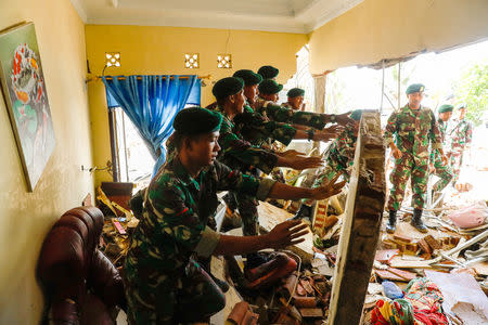 Soldiers search for bodies under a collapsed wall in a beach front hotel, which was hit by a tsunami in Pandeglang, Banten province, Indonesia, December 24, 2018. REUTERS/Jorge Silva