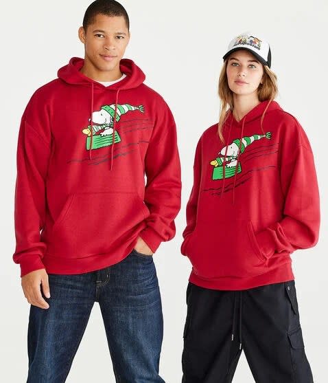 models wearing red hoodie with snoopy and woodstock sledding