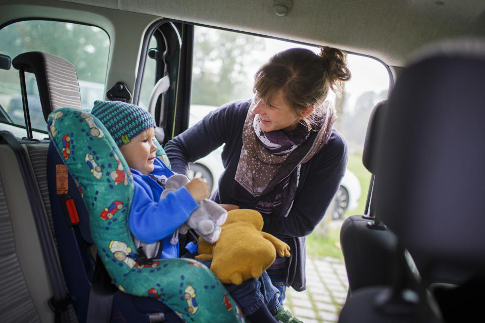 MARZLING, GERMANY - SEPTEMBER 27: Mother is fastening the seat belt of her son in the back of a car. (Photo by Thomas Trutschel/Photothek via Getty Images)