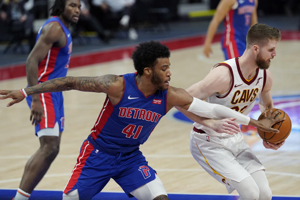 Detroit Pistons forward Saddiq Bey (41) reaches in on Cleveland Cavaliers forward Dean Wade during the second half of an NBA basketball game, Monday, April 19, 2021, in Detroit. (AP Photo/Carlos Osorio)