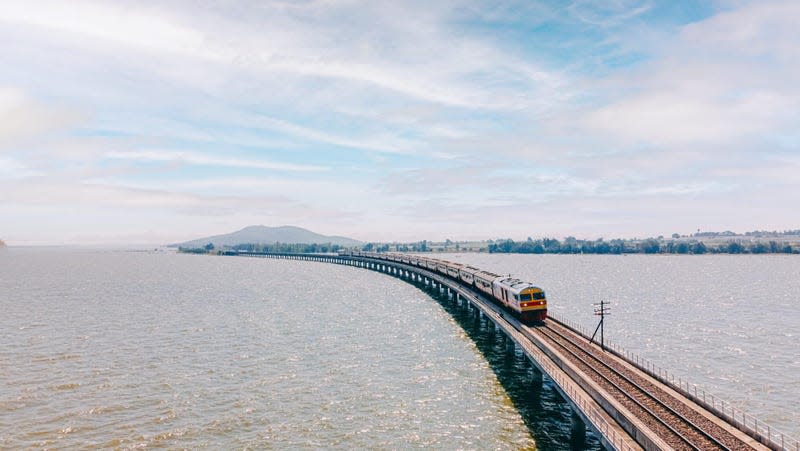 state railway of thailand crosses track across flooded area -- appears to float above the water