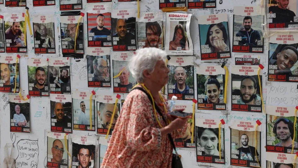 PHOTO: A woman walks by posters put up in support of hostages who were kidnapped during the deadly October 7 attack, in Tel Aviv, Israel, Apr. 29, 2024.  (Shannon Stapleton/Reuters)