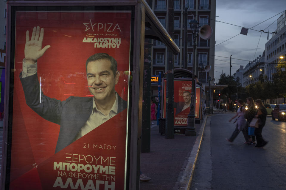 Three women cross the street among election banners depecting the leader of the main opposition Syriza party, Alexis Tsipras, in Athens, on Monday, May 15, 2023. Greeks go to the polls Sunday, May 21, in the first general election held since the country ended successive international bailout programs and strict surveillance period imposed by European leaders. Conservative Prime Minister Kyriakos Mitsotakis is seeking a second four-year term and is leading in opinions but may need a coalition partner to form the next government. (AP Photo/Petros Giannakouris)