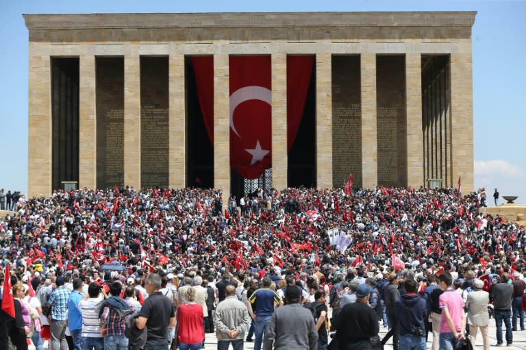 People hold Turkish flags in front of the mausoleum of Mustafa Kemal Ataturk in Ankara, on May 19, 2016