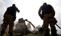 <p>Municipal guards observe the demolition of a house in the Vila Autodromo community, surrounded by construction work for the Rio 2016 Olympic Park, in Rio de Janeiro, Brazil, March 8, 2016. (REUTERS/Ricardo Moraes)</p>