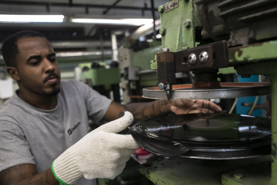 Un operador recorta un disco prensado de la producción de discos de vinilo en la fábrica Polysom en Belford Roxo, Brasil, el martes 16 de abril de 2024. El regreso del vinilo a Brasil sigue una tendencia global de los últimos 15 años. En Estados Unidos, los ingresos por discos de vinilo alcanzaron los 1.400 millones de dólares en 2023, según Recording Industry Association of America. (Foto AP/Bruna Prado)