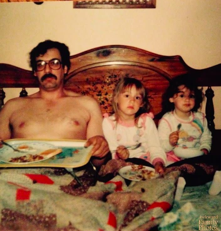 "This was taken by my mother on Father’s Day 1986. My sister (far right) and I are less than thrilled to be missing morning cartoons. Not to mention our king-for-a-day dad obviously scored the only tray in the house so my eggs were precariously balanced on my lap. As for my sister’s cereal… that most likely ended up in the bed as well.”