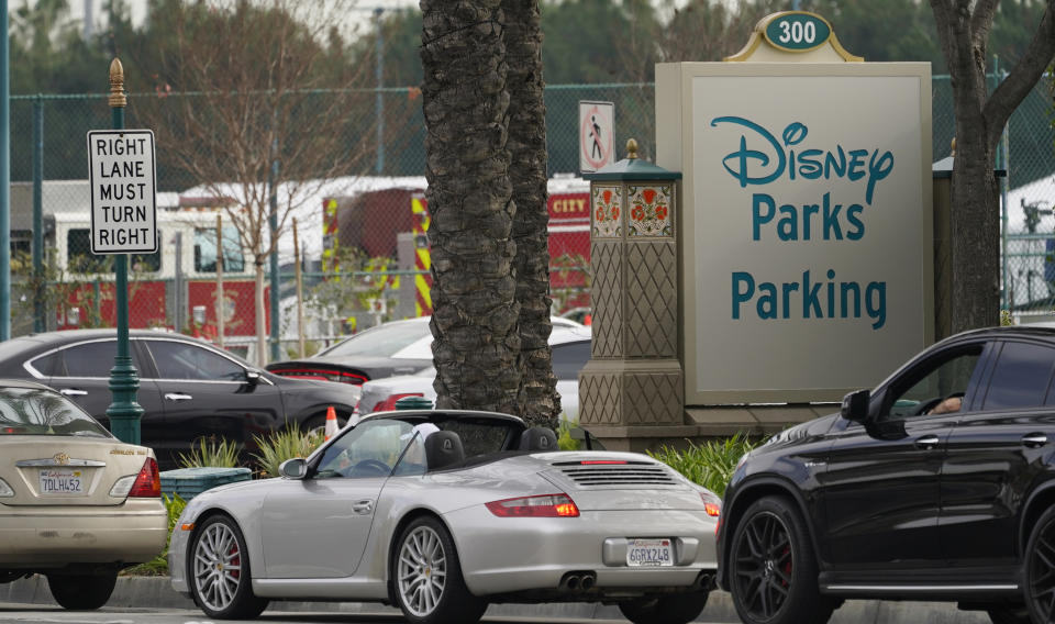 Vehicles queue up outside the Disneyland Resort parking lot for a COVID-19 vaccine in Anaheim, Calif., Wednesday, Jan. 13, 2021. The parking lot is located off Katella Avenue and sits southeast of Disneyland. California is immediately allowing residents 65 and older to get scarce coronavirus vaccines, Gov. Gavin Newsom announced Wednesday. (AP Photo/Damian Dovarganes)