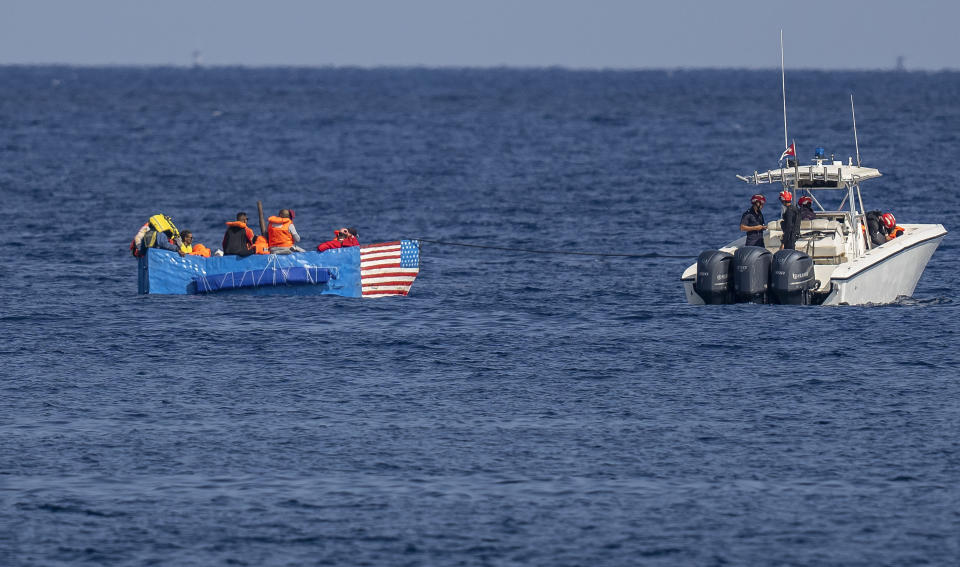 People in a makeshift boat with the U.S. flag painted on the side are captured by the Cuban Coast Guard near the Malecon seawall in Havana, Cuba, Monday, Dec. 12, 2022. (AP Photo/Ramon Espinosa)
