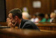 Oscar Pistorius sits in the dock as he listens to cross questioning about the events surrounding the shooting death of his girlfriend Reeva Steenkamp, in court during his trial in Pretoria, South Africa, Monday, March 10, 2014. Pistorius is charged with the shooting death of his girlfriend Steenkamp in 2013. (AP Photo/Siphiwe Sibeko, Pool)