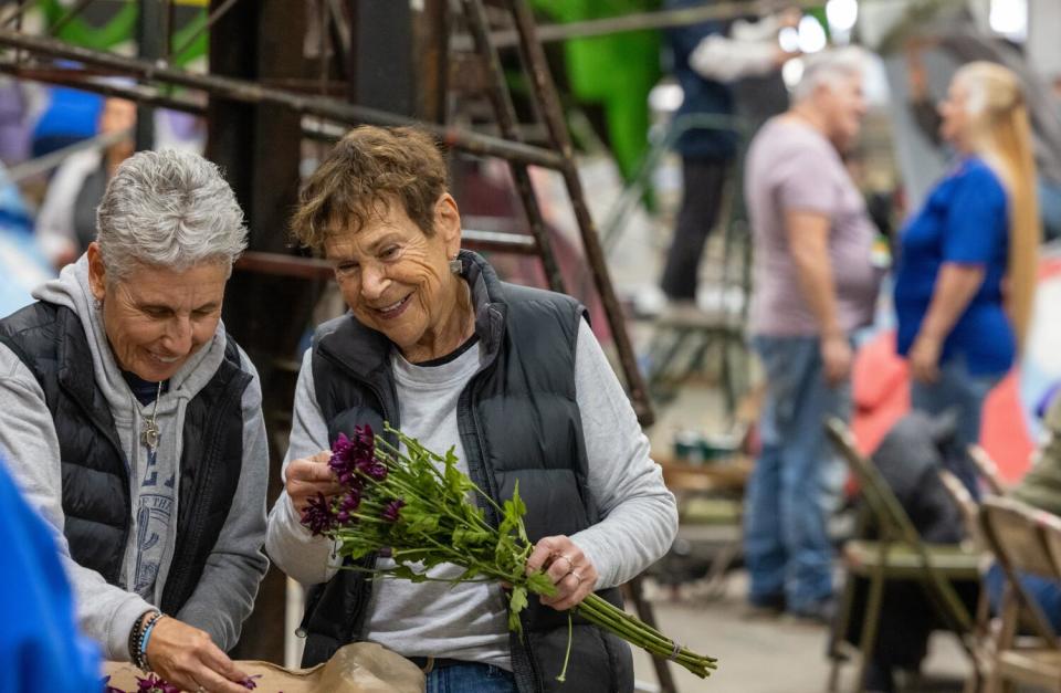 Volunteers cut flowers for Rose Parade floats at Phoenix Decorating Co. in Irwindale.