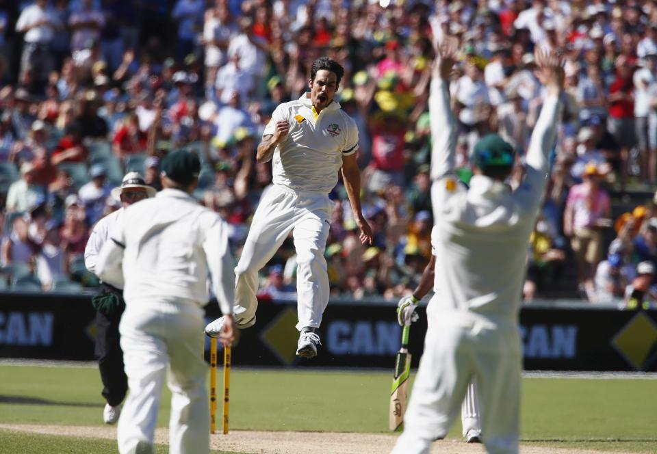 Australia's Mitchell Johnson (C) celebrates with teammates after taking the wicket of England's captain Alastair Cook during the second day's play in the second Ashes cricket test at the Adelaide Oval December 6, 2013