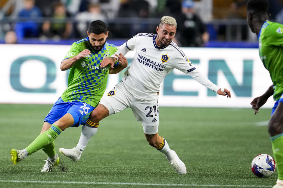 Seattle Sounders midfielder Alex Roldan (16) and LA Galaxy forward Diego Fagúndez (21) vie for the ball during the first half of an MLS soccer match Wednesday, Oct. 4, 2023, in Seattle. (AP Photo/Lindsey Wasson)