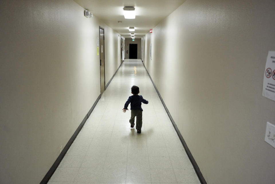 FILE - In this Dec. 11, 2018 file photo, an asylum-seeking boy from Central America runs down a hallway after arriving from an immigration detention center to a shelter in San Diego. Lawyers for eight immigrant families separated under Trump administration policy filed claims Monday, Feb. 11, 2019, against the U.S. government demanding $6 million each in damages for what they describe as lasting trauma. (AP Photo/Gregory Bull, File)