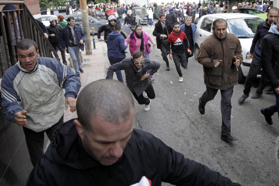 Algerian demonstrators clash with security forces as they take to the streets in the capital Algiers to reject the presidential elections, in Algeria, Thursday, Dec. 12, 2019. Five candidates have their eyes on becoming the next president of Algeria _ without a leader since April _ in Thursday's contentious election boycotted by a massive pro-democracy movement. (AP Photo)