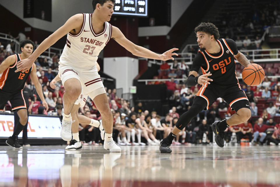 Oregon State guard Jordan Pope (0) is defended by Stanford forward Brandon Angel (23) during the second half of an NCAA college basketball game Saturday, Feb. 24, 2024, in Stanford, Calif. (AP Photo/Nic Coury)