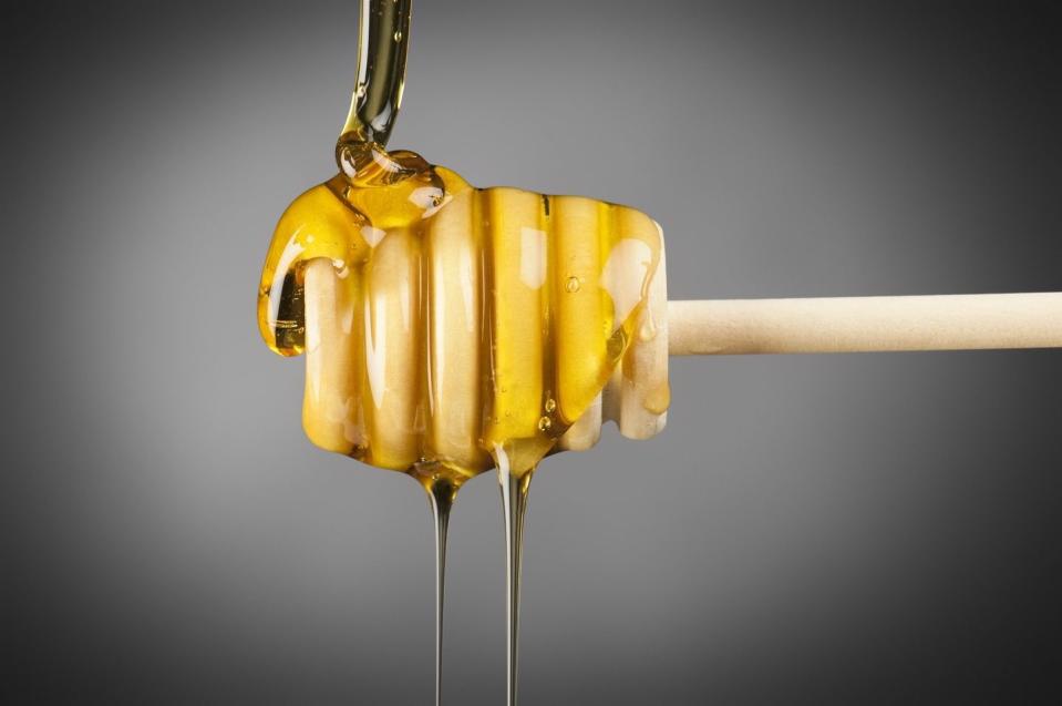 honey drizzler with golden manuka honey pouring of it