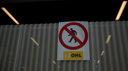 The logo of Spanish constructor OHL is seen attached to a fence at a construction site in Madrid, Spain, March 29, 2017. REUTERS/Sergio Perez