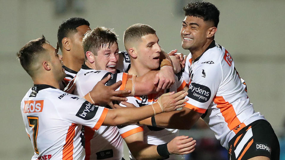 Pictured here, Wests Tigers players celebrate Saturday night's come-from-behind win over Manly.