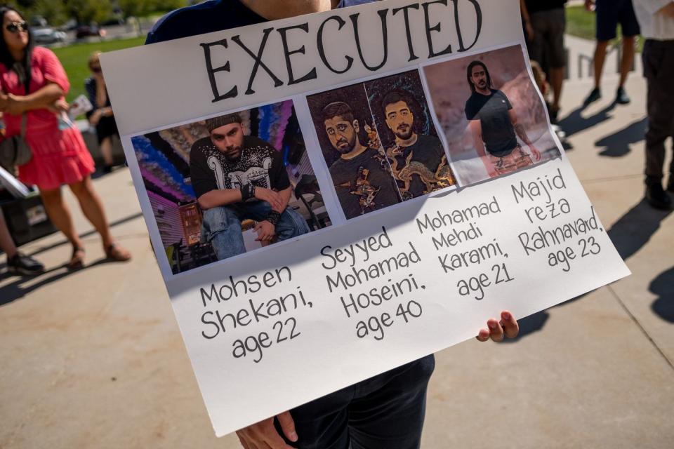 A protester holds a sign at the Capitol in Salt Lake City on Saturday. The sign shows images of protesters in Iran who have been killed during a protests against the Iranian regime  The protest in Salt Lake City was held on the one-year anniversary of the death of Mahsa Amini, who was arrested by Iran’s morality police for allegedly violating the country’s strict dress code for women.