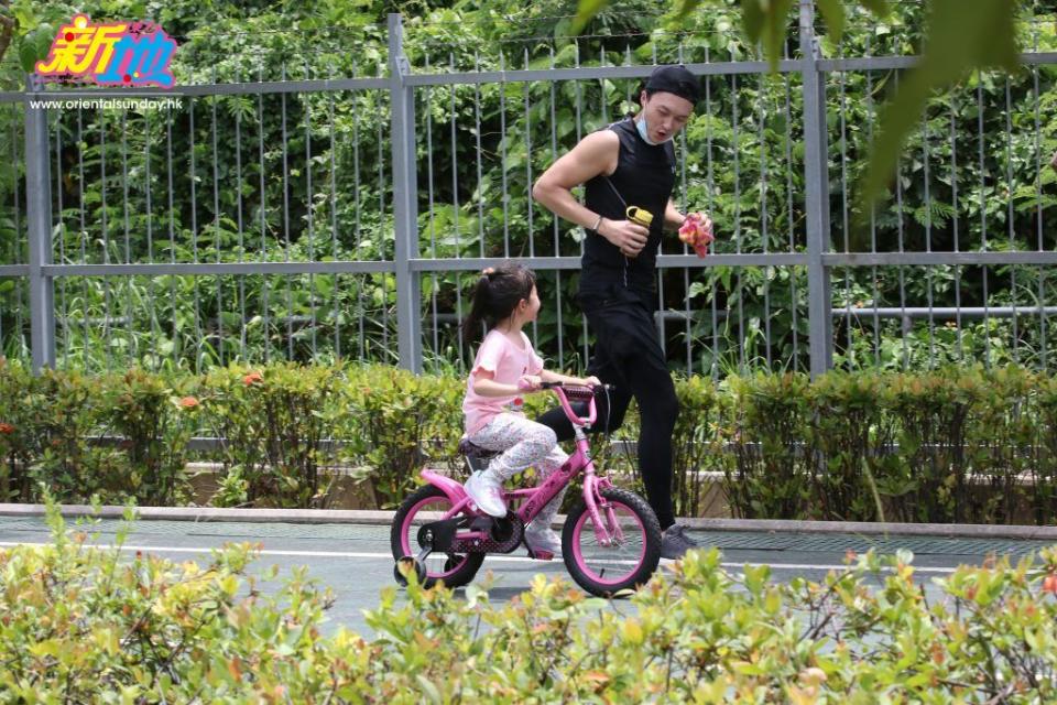 阿女踩車阿爸跑步，兩父女非常合拍。