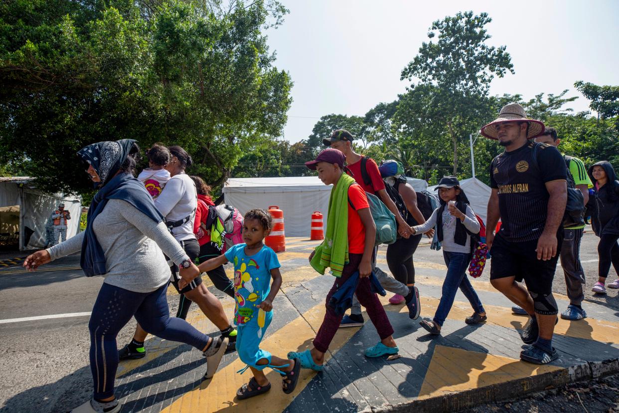 Migrants walk past a Mexican immigration checkpoint without being stopped by Mexican officials as they head north toward Tapachula in October 2023.