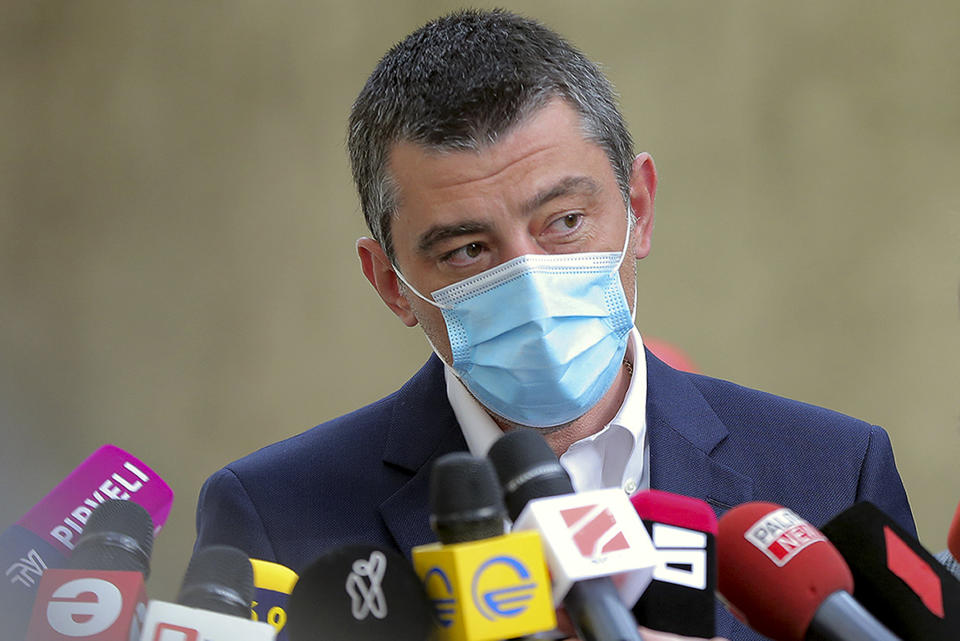 In this handout photo released by Georgia's Prime Minister Press Office, Georgia's Prime Minister Giorgi Gakharia, wearing a face mask to help curb the spread of the coronavirus, speaks to the media after voting at a polling station during the parliamentary elections in Tbilisi, Georgia, Saturday, Oct. 31, 2020. The hotly contested election between the Georgian Dream party, created by billionaire Bidzina Ivanishvili who made his fortune in Russia and has held a strong majority in parliament for eight years, and an alliance around the country's ex-President Mikheil Saakashvili, who is in self-imposed exile in Ukraine. (Georgia's Prime Minister Press office via AP)