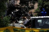 A worker walks past a truck loaded with the wreckage of the crashed plane, in Karachi,