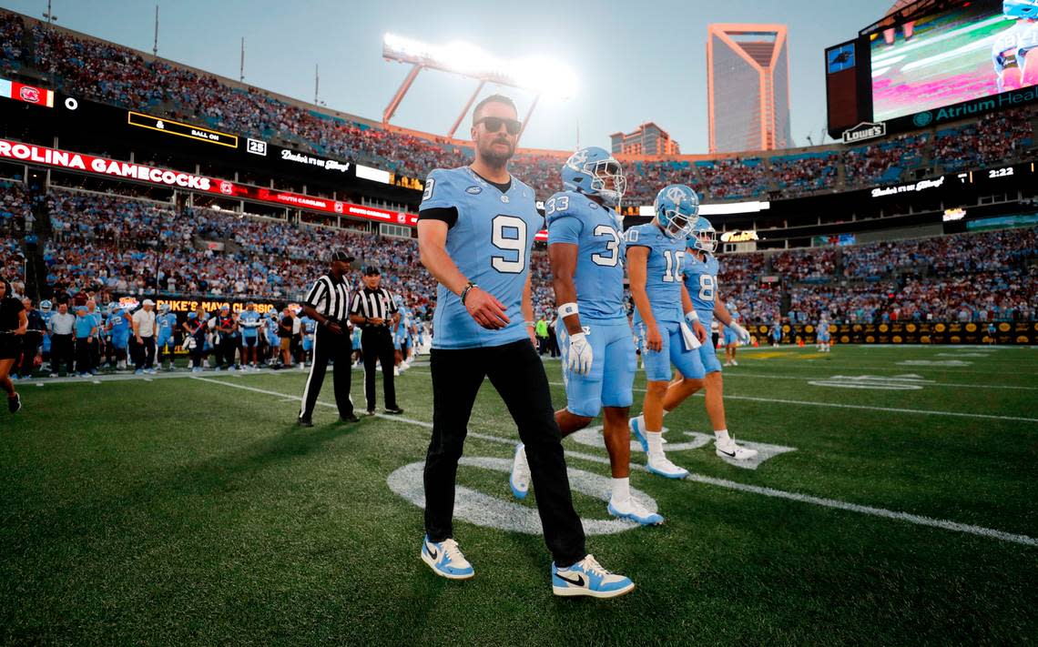 Eric Church, wearing Tez Walker’s jersey, walks out with the captains for the coin toss before UNC’s game against South Carolina in the Duke’s Mayo Classic at Bank of America Stadium in Charlotte, N.C., Saturday, Sept. 2, 2023.